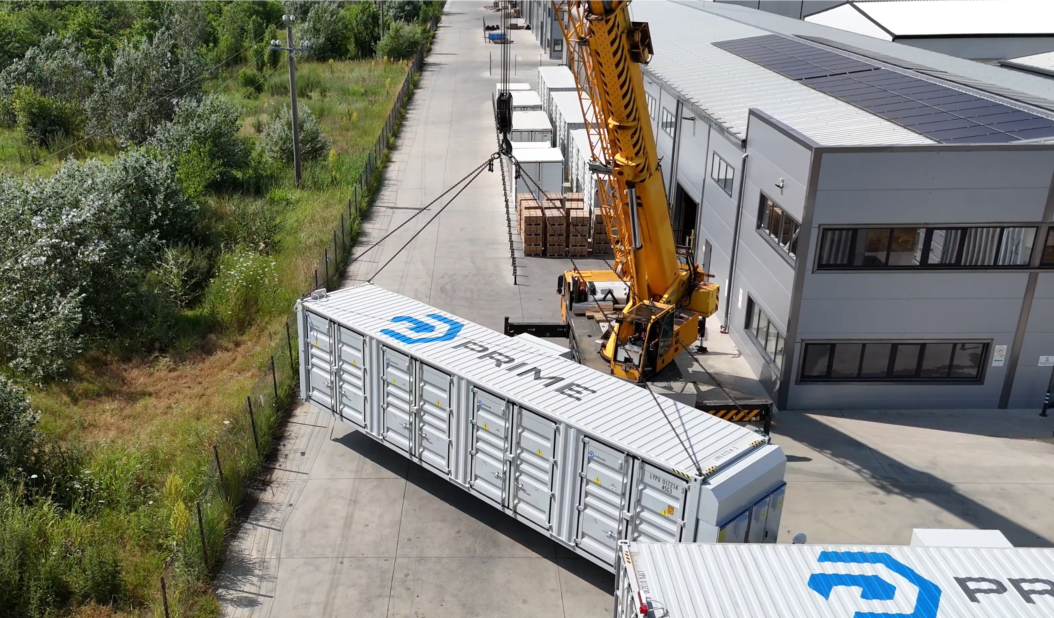 Aerial view of Prime Batteries container delivery at facility with crane